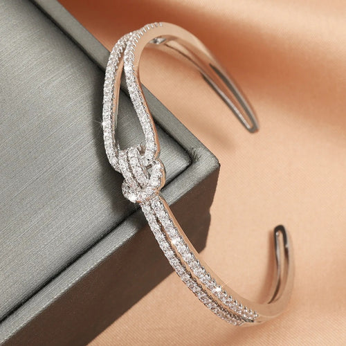 Side view of polished gold knot bangle showing the elegant craftsmanship